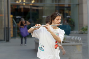 Boy playing flute in a public place